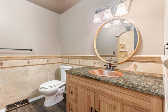 bathroom with visible vents, toilet, wainscoting, vanity, and wood finished floors