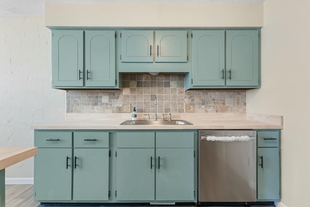 kitchen with tasteful backsplash, light countertops, a sink, green cabinetry, and dishwasher