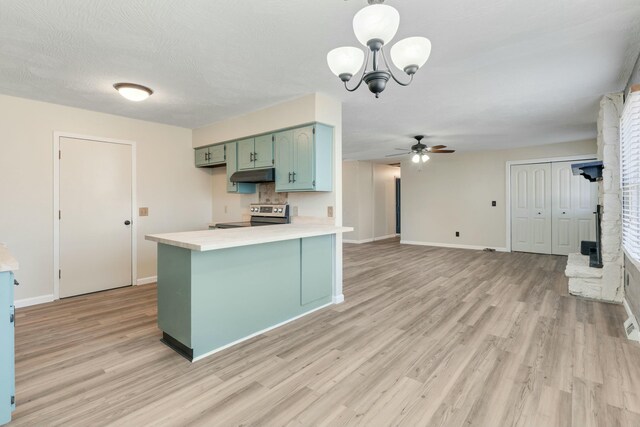kitchen featuring under cabinet range hood, a peninsula, light wood-style floors, light countertops, and stainless steel electric range