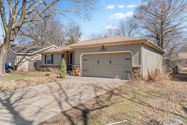 ranch-style home with a garage, stone siding, and driveway