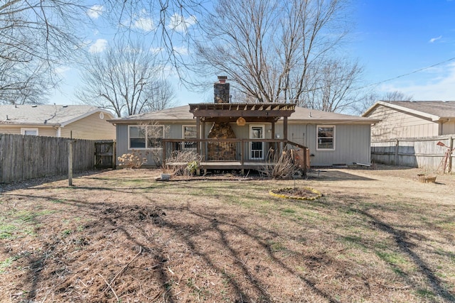 back of house featuring a fenced backyard, a chimney, and a wooden deck