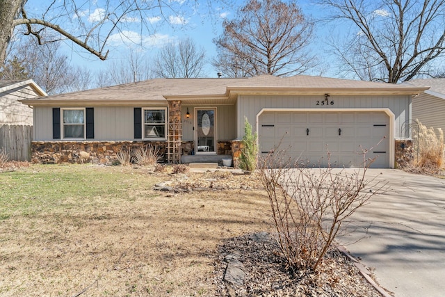 ranch-style home featuring a garage, concrete driveway, stone siding, fence, and a front yard