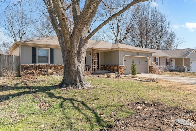 ranch-style house with concrete driveway, a front yard, fence, a garage, and stone siding