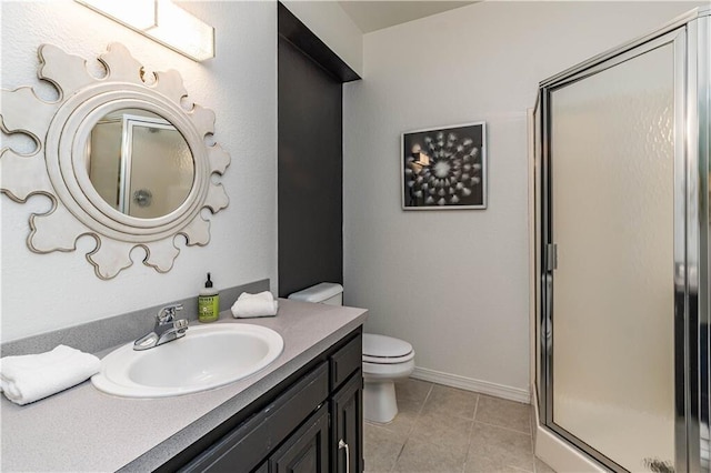 full bathroom with toilet, a stall shower, vanity, baseboards, and tile patterned floors