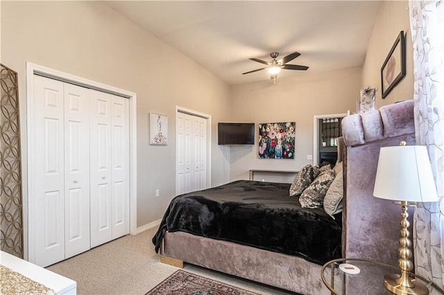 carpeted bedroom featuring a ceiling fan, baseboards, and two closets