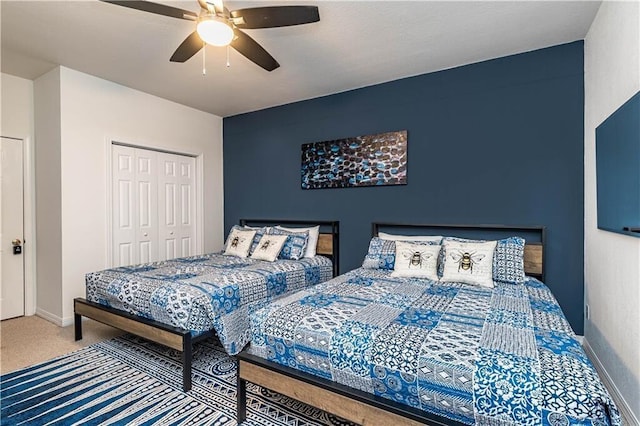 carpeted bedroom with a ceiling fan, a closet, and baseboards