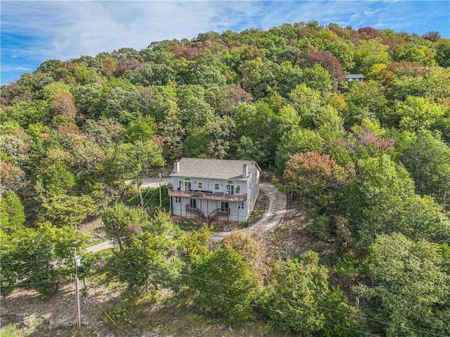 drone / aerial view featuring a wooded view