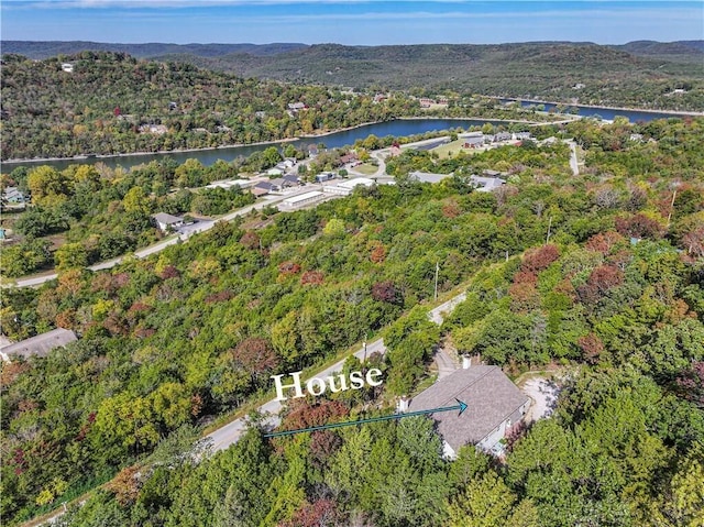 drone / aerial view with a water view and a wooded view