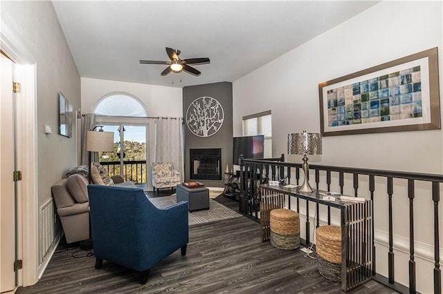 living room featuring a fireplace, a ceiling fan, and wood finished floors