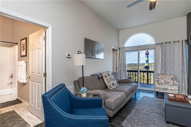 living area featuring a ceiling fan, lofted ceiling, baseboards, and wood finished floors