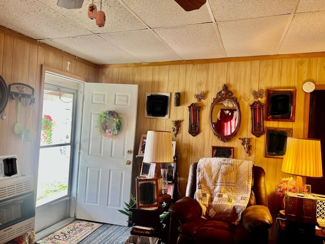 interior space with heating unit, wooden walls, and a paneled ceiling