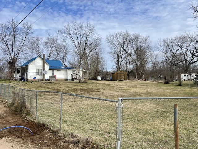 view of yard featuring a fenced backyard, an outdoor structure, and a shed