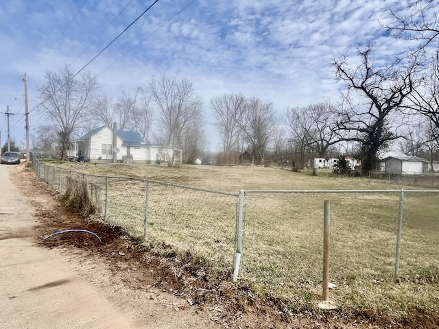 view of yard with fence and a rural view