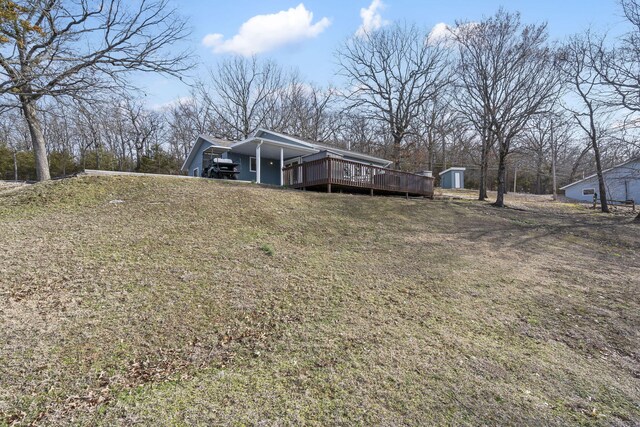 view of front facade featuring a shed, a front lawn, an outdoor structure, and a wooden deck