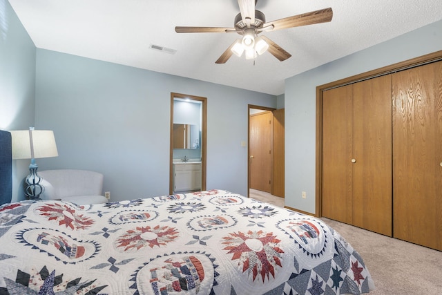 bedroom with ceiling fan, a textured ceiling, light carpet, visible vents, and a closet