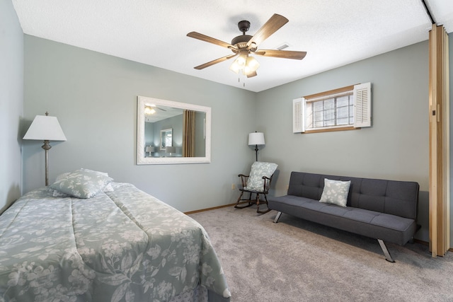 carpeted bedroom with a textured ceiling, a ceiling fan, and baseboards