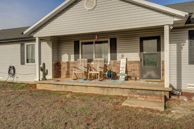 back of house featuring a porch and brick siding