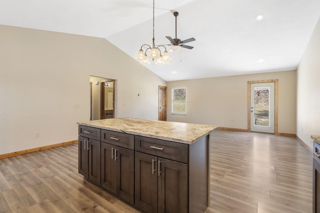 kitchen featuring lofted ceiling, light wood finished floors, and baseboards