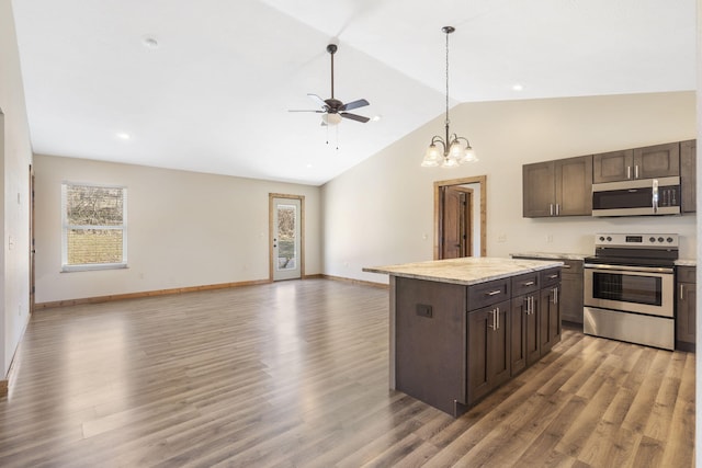 kitchen featuring appliances with stainless steel finishes, open floor plan, and dark brown cabinets