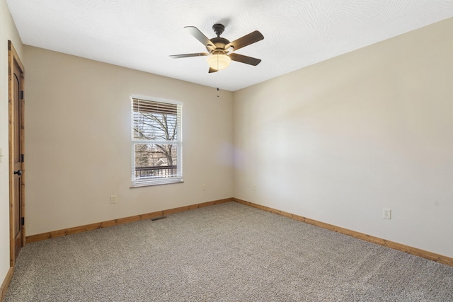 spare room with visible vents, light carpet, ceiling fan, a textured ceiling, and baseboards