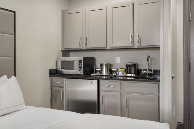 bar with appliances with stainless steel finishes and a sink