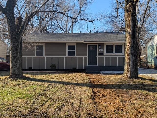 single story home with entry steps and a front lawn