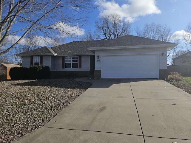 ranch-style home with a garage, fence, concrete driveway, and roof with shingles