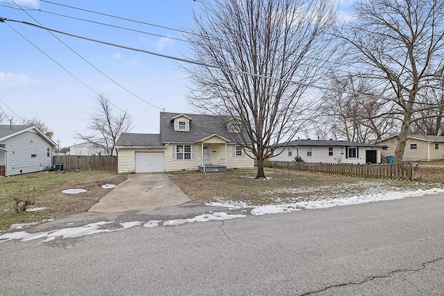 view of front of home with driveway, a fenced front yard, and an attached garage