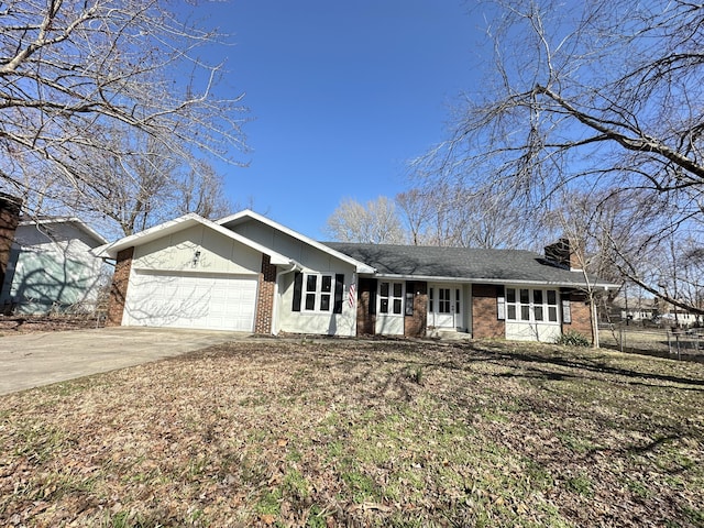 single story home featuring a garage, a chimney, concrete driveway, and brick siding