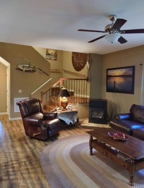 living room featuring stairs, ceiling fan, wood finished floors, and baseboards