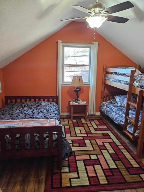 bedroom with vaulted ceiling and wood finished floors