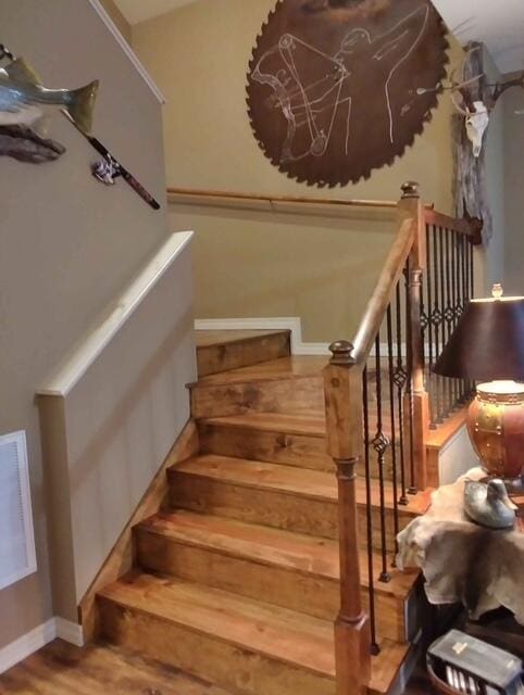 stairway with wood finished floors and baseboards