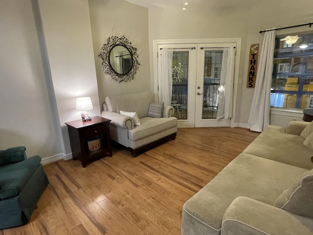 sitting room with french doors, light wood-style flooring, and baseboards