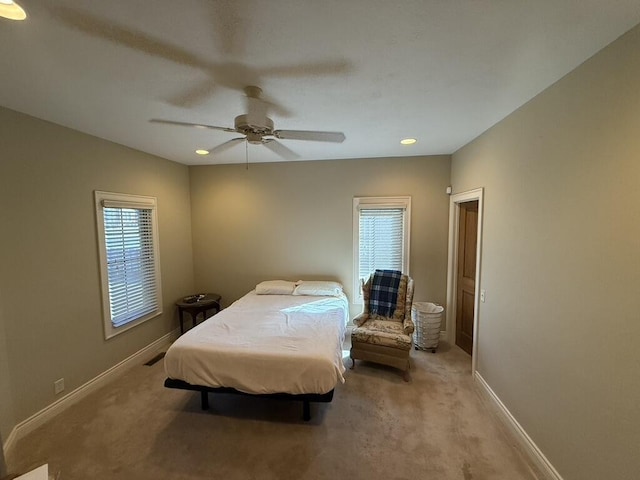 carpeted bedroom with visible vents, baseboards, and a ceiling fan