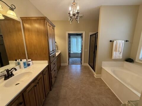 full bathroom with baseboards, vanity, a bath, and a shower stall