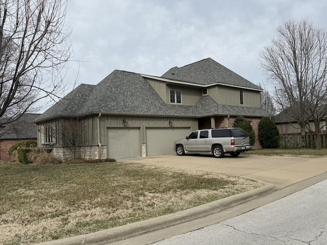 view of front of house with roof with shingles, concrete driveway, and an attached garage