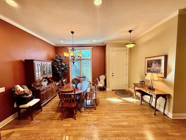 dining space with a notable chandelier, baseboards, crown molding, and light wood-style floors