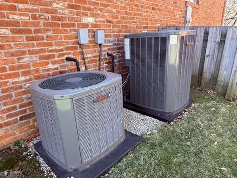 exterior details featuring cooling unit, fence, and brick siding