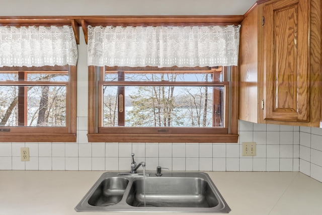 kitchen with light countertops, plenty of natural light, a sink, and decorative backsplash