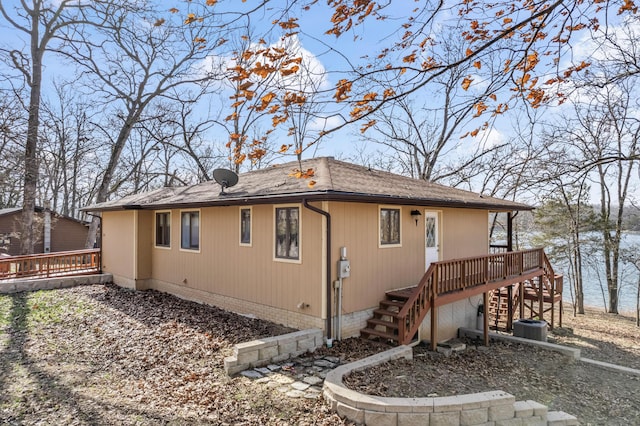 back of house with stairs, a shingled roof, a deck, and central AC unit