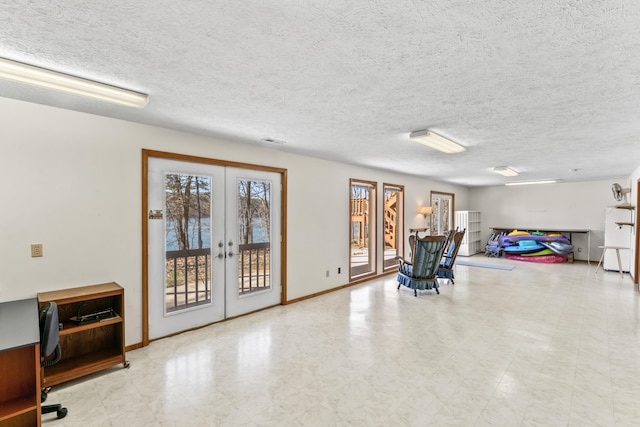 interior space with baseboards, a textured ceiling, and french doors