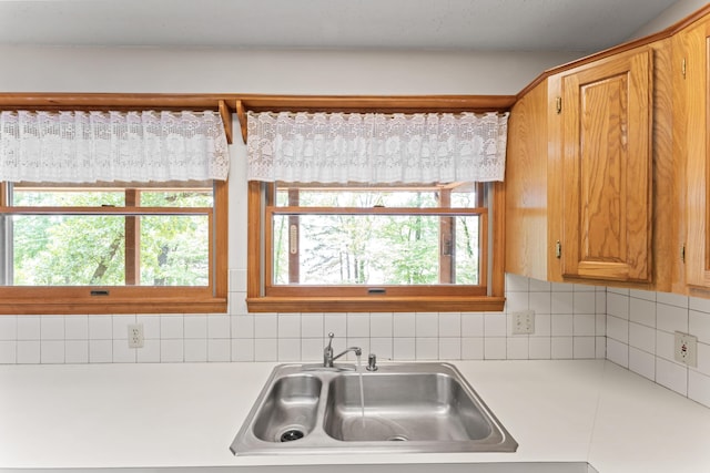 24311 Raintree Ln, Shell Knob, MO 65747 - kitchen featuring light countertops, a sink, decorative backsplash, and brown cabinets