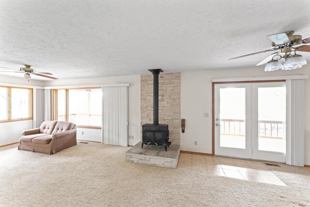 24311 Raintree Ln, Shell Knob, MO 65747 - living room featuring healthy amount of natural light, a wood stove, carpet flooring, and a textured ceiling