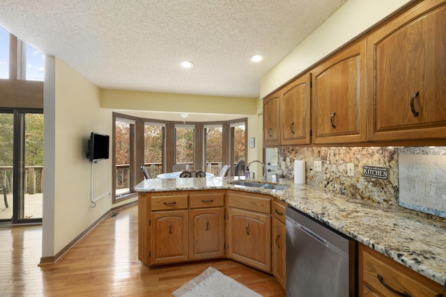 kitchen with a wealth of natural light, a sink, a peninsula, and stainless steel dishwasher