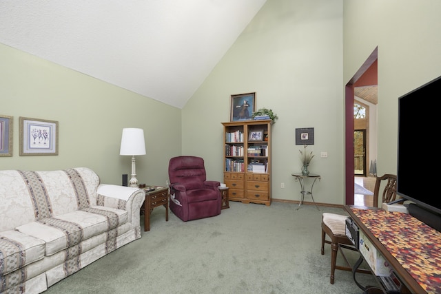 carpeted living area featuring high vaulted ceiling and baseboards