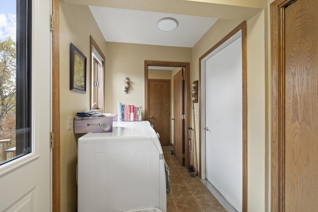 laundry area featuring separate washer and dryer and dark tile patterned flooring