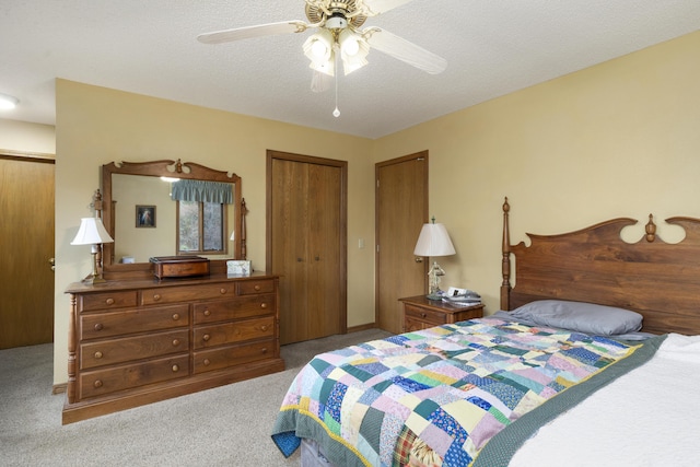 carpeted bedroom featuring a textured ceiling, a closet, and a ceiling fan