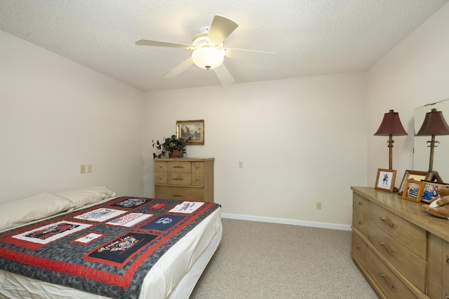 bedroom with a ceiling fan, light colored carpet, a textured ceiling, and baseboards