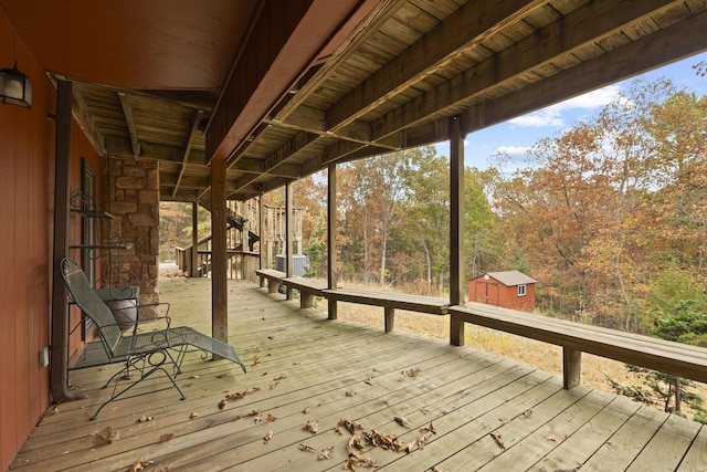 wooden terrace featuring a shed and an outdoor structure