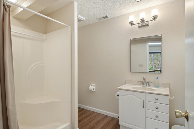 full bath with a textured ceiling, wood finished floors, visible vents, and a shower with curtain